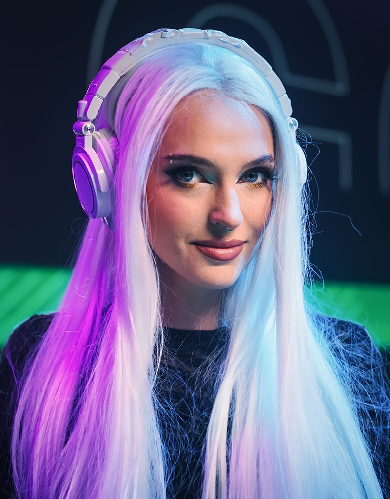 A female DJ performing amidst lights and sound